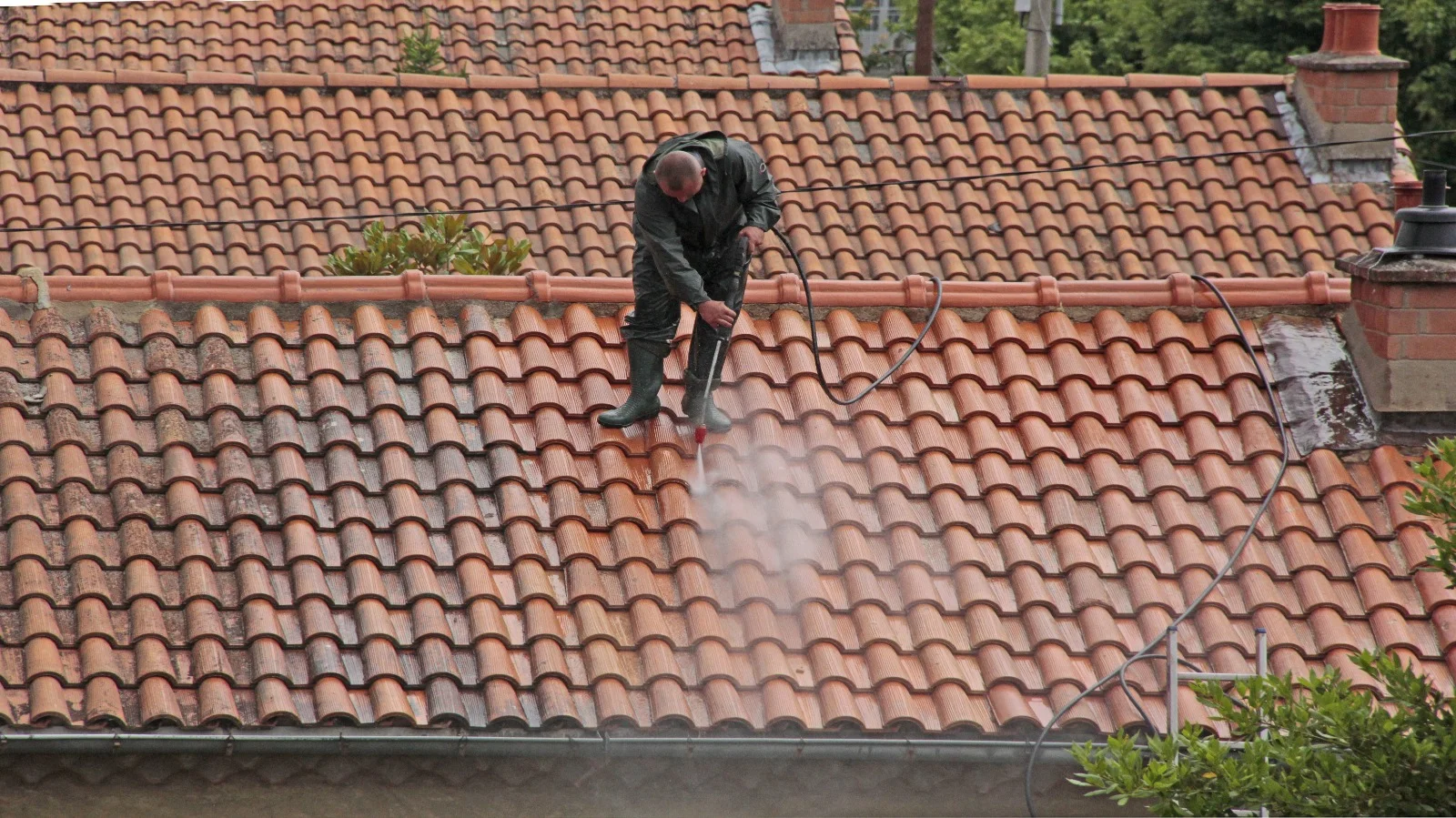 Technicien nettoyant une toiture en tuiles